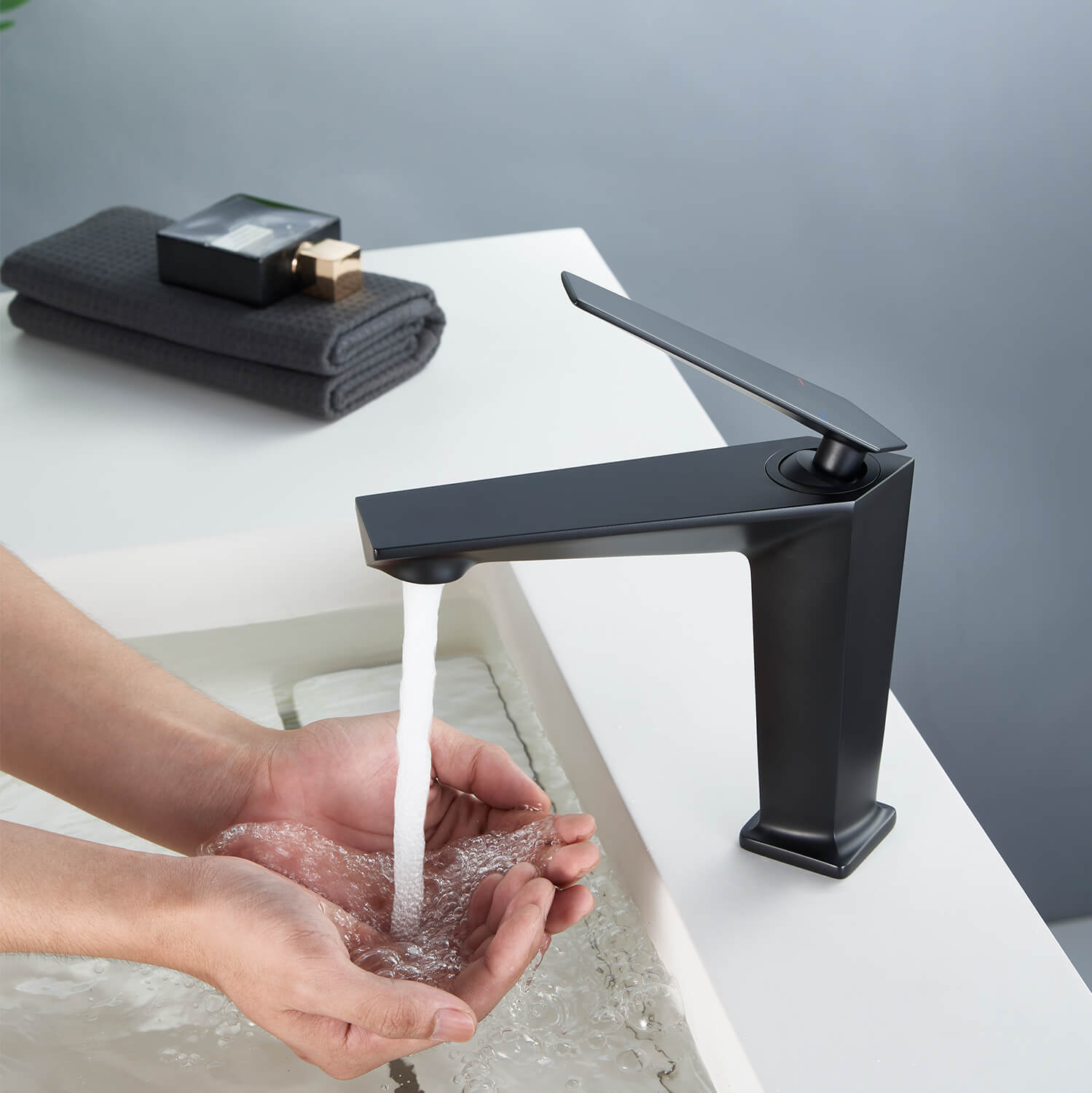 Hand holding water from matte black splash proof bathroom faucet with aerator